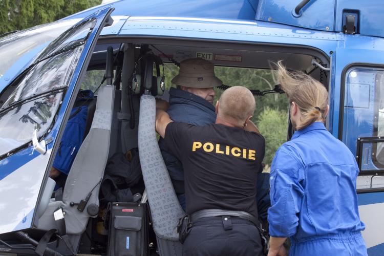 Policisté umisťují zesláblého muže do vrtulníků