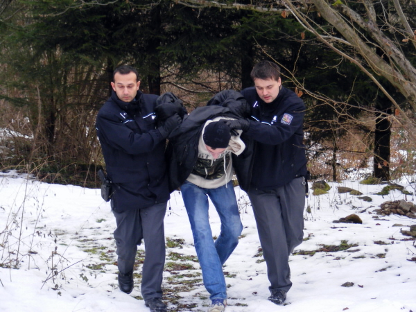 Policisté odvádějí pachatele