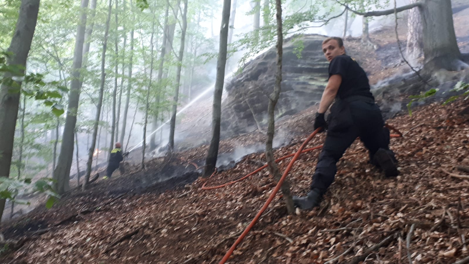 policisté pomáhají při hašení ohně